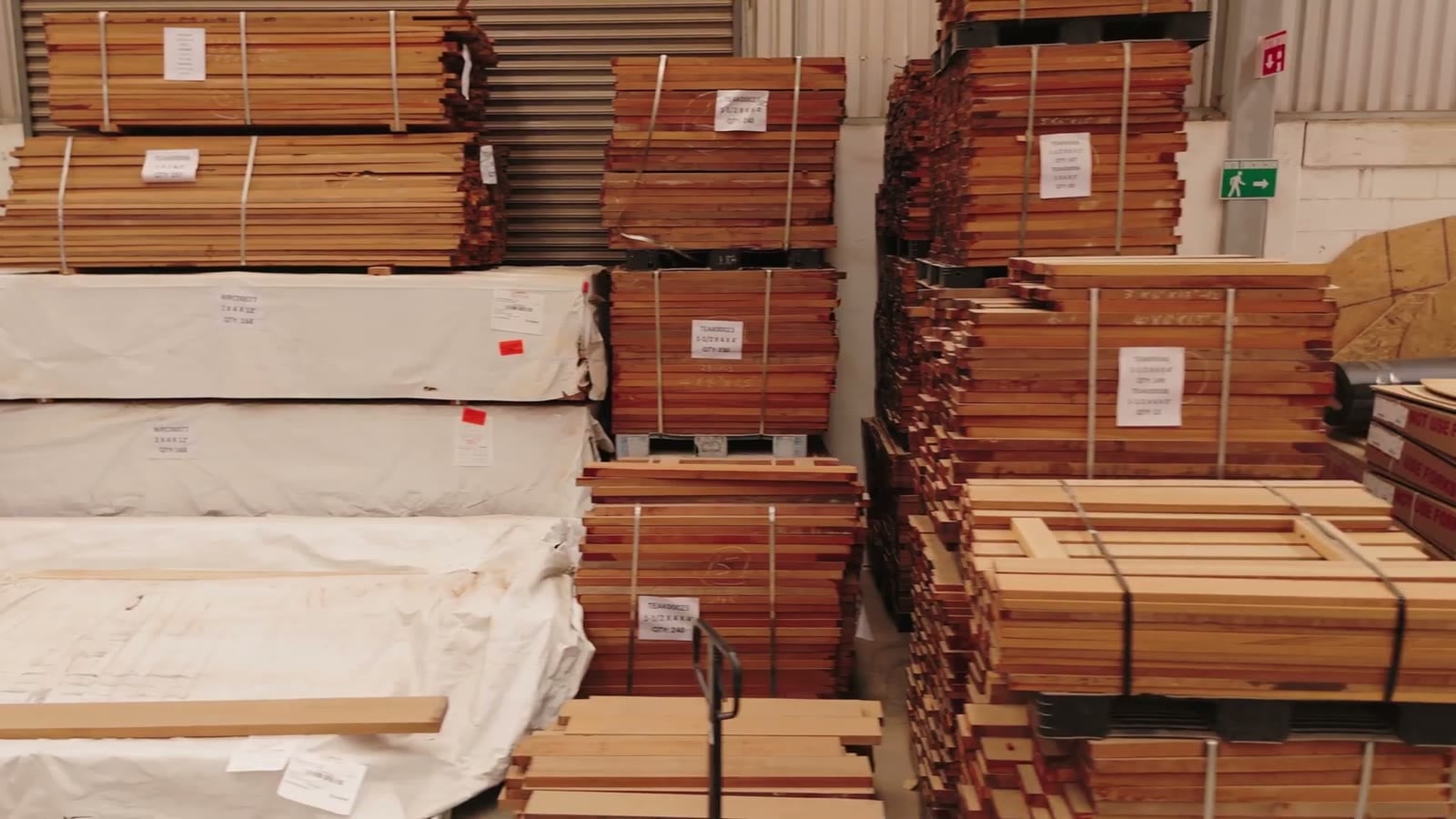 Stacks of wood boards on pallets in a storage area